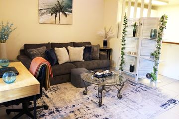 Gainesville apartment for rent - A living room with a couch, a table, and a painting on the wall.