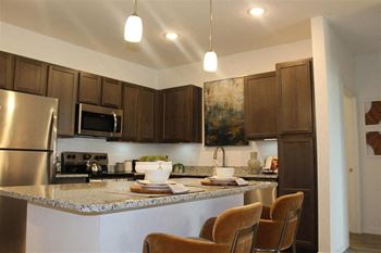 Kitchen islands w/pendant lighting and ample cabinet space
