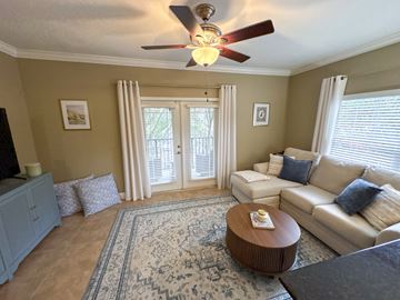 Gainesville townhouse for rent - A living room with a ceiling fan and a rug on the floor.