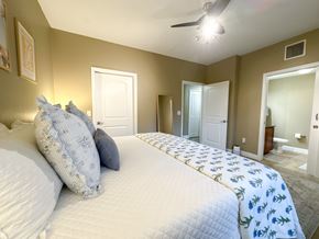 Gainesville townhouse for rent - A bedroom with a large bed and a ceiling fan.