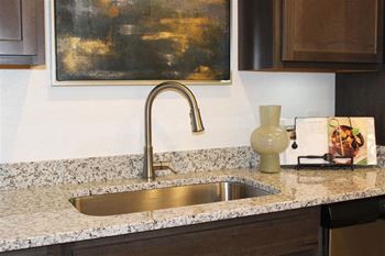 Stainless steel single basin sink with pull-down goose-neck faucet and heavy duty wisp-away disposal