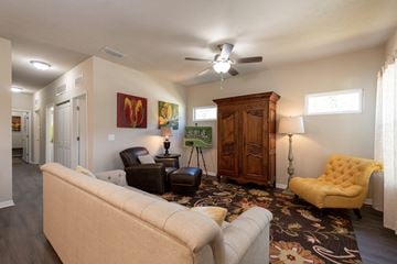 Gainesville apartment for rent - a living room with a couch and chairs and a ceiling fan