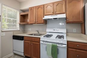 Mountain Brook apartment for rent - A kitchen with a white stove and wooden cabinets.