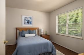 Mountain Brook apartment for rent - A bedroom with a bed, nightstand, and a window with blinds.