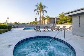 Largo apartment for rent - A hot tub with a blue tiled edge sits in the middle of a patio.