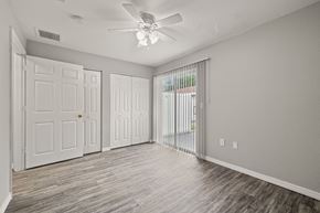 Tampa apartment for rent - an empty living room with white doors and a ceiling fan