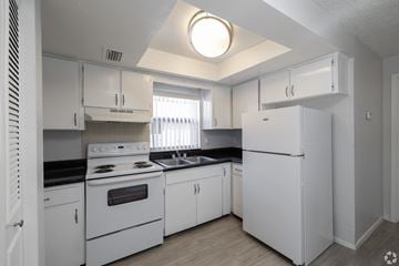 St. Petersburg apartment for rent - A white kitchen with a black countertop and stove.
