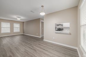 Jacksonville apartment for rent - A room with a wooden floor and a window with blinds.
