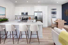 Apollo Beach townhouse for rent - A modern kitchen with white cabinets and a large island with bar stools.
