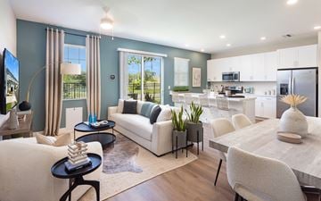 Apollo Beach townhouse for rent - A modern living room with a white sofa and a wooden dining table.