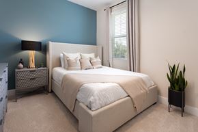 Apollo Beach townhouse for rent - A bedroom with a large bed and a potted plant.