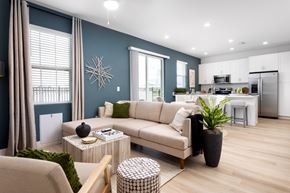 Apollo Beach townhouse for rent - A modern living room with a beige sofa, a coffee table, and a potted plant.
