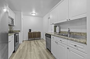Troy apartment for rent - Galley kitchen with granite countertops and white cabinets at Regents Club of Troy Apartments, Troy, MI 48084