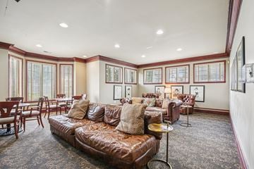 Troy apartment for rent - A living room with a brown leather couch and a patterned carpet.