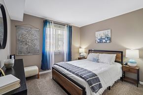 Brighton apartment for rent - A bedroom with a large bed and a painting on the wall.