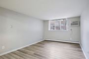 Oak Park apartment for rent - A room with wooden flooring and a window with bars on it.