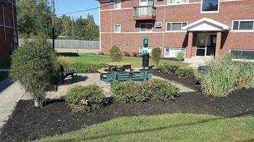 Indianapolis apartment for rent - A small garden area in front of a brick building.