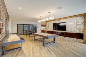 Detroit apartment for rent - a game room with two ping pong tables and a television