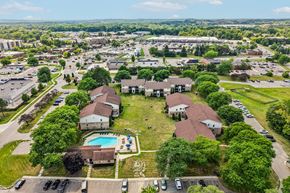 Brighton apartment for rent - A bird's eye view of a residential area with houses, a swimming pool, and a parking lot.