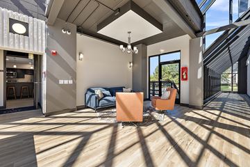 Troy apartment for rent - A modern living room with a blue sofa and orange chairs.