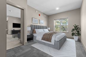 Holt apartment for rent - A modern bedroom with a large bed and a flat-screen TV.