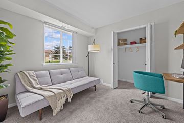 Shelby Township apartment for rent - A living room with a grey couch and a green chair.