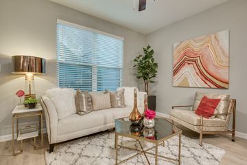 Dallas apartment for rent - A living room with a white couch, a glass coffee table, and a painting on the wall.