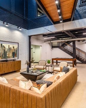 Detroit apartment for rent - A living room with a couch, coffee table, and a staircase.