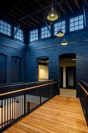 Detroit apartment for rent - A long wooden walkway leads to a doorway in a brick building.