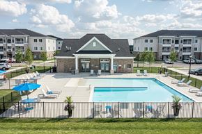 Shelby Township apartment for rent - Overview of the clubhouse and pool, various seats around pool.