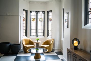 Detroit apartment for rent - a living room with yellow chairs and a table and windows