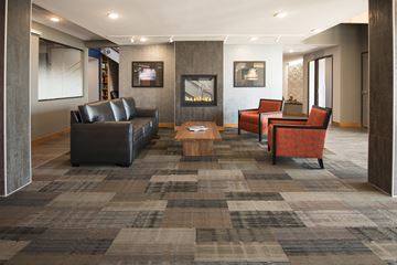 Duluth apartment for rent - A living room with a grey carpet and a black leather couch.