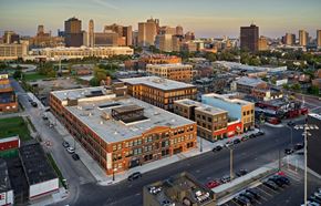 Detroit apartment for rent - an aerial view of a large brick building with a gray roof with a city in the background