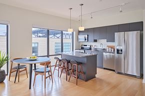 Detroit apartment for rent - an open kitchen and dining area with stainless steel appliances and a round table