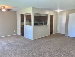 Southfield apartment for rent - an empty living room with a kitchen and a ceiling fan