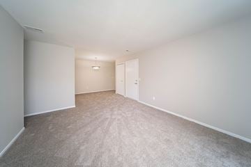 Waterford apartment for rent - a spacious living room with carpet and white walls