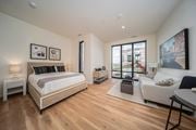 Detroit apartment for rent - a bedroom with a bed and a couch and a large window