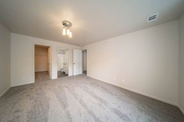 Flint apartment for rent - a spacious living room with carpet and white walls