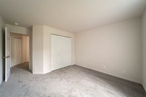 Flint apartment for rent - a bedroom with white walls and carpet and a door to a closet