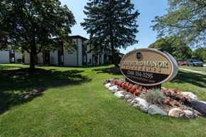 Southfield apartment for rent - a sign in front of a grassy area with trees in the background