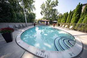 Southfield apartment for rent - a round swimming pool with lounge chairs and trees in the background