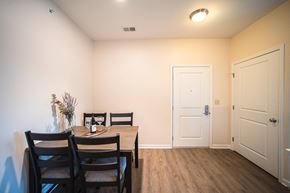 Shelby Township apartment for rent - Dining room with table against wall, wine glasses on table, door on the right side of room.
