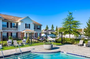 Grand Blanc apartment for rent - a swimming pool with chairs and umbrellas in front of a house