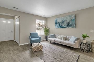Lansing apartment for rent - a living room with a white couch and a blue chair