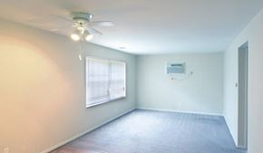 Columbus apartment for rent - Living room with grey carpet, white walls, a large picture window and ceiling fan.