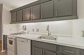 Royal Oak apartment for rent - a kitchen with white appliances and gray cabinets