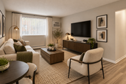 Oak Park apartment for rent - A living room with a white couch, a chair, a coffee table, and a flat screen TV mounted on the wall.