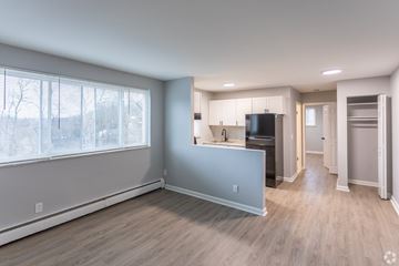 Cincinnati apartment for rent - A kitchen with a black fridge and white cabinets.