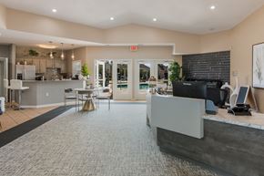 Grand Blanc apartment for rent - a clubhouse with a reception desk and a kitchen with a table and chairs