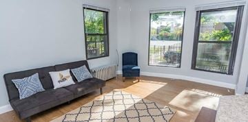 Chicago apartment for rent - A living room with a grey couch and a blue chair.